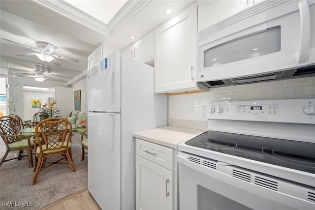 kitchen with decorative backsplash, white appliances, crown molding, white cabinets, and light hardwood / wood-style floors