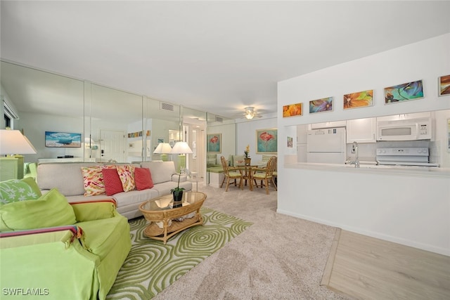 living room with light hardwood / wood-style floors and sink