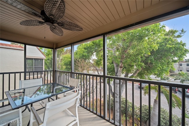 unfurnished sunroom featuring ceiling fan and wood ceiling