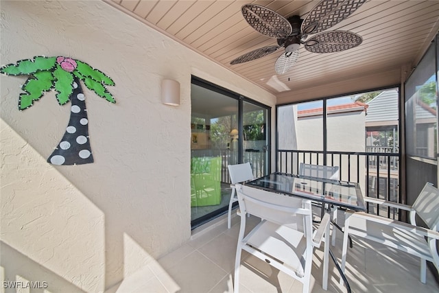 sunroom with ceiling fan and wooden ceiling