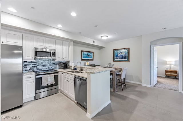 kitchen featuring kitchen peninsula, sink, white cabinetry, and stainless steel appliances