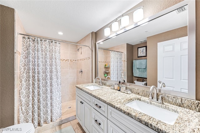 bathroom with walk in shower, tile patterned flooring, a textured ceiling, toilet, and vanity