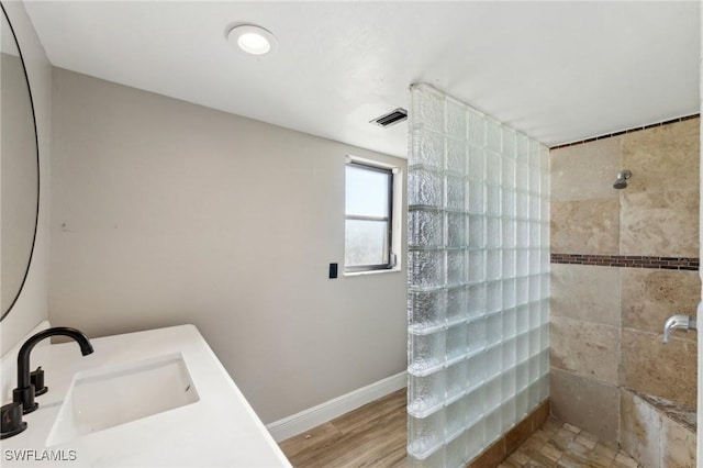 bathroom featuring sink, a shower, and wood-type flooring