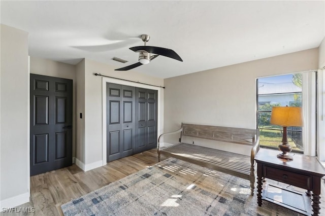 bedroom featuring ceiling fan, light hardwood / wood-style floors, and a closet