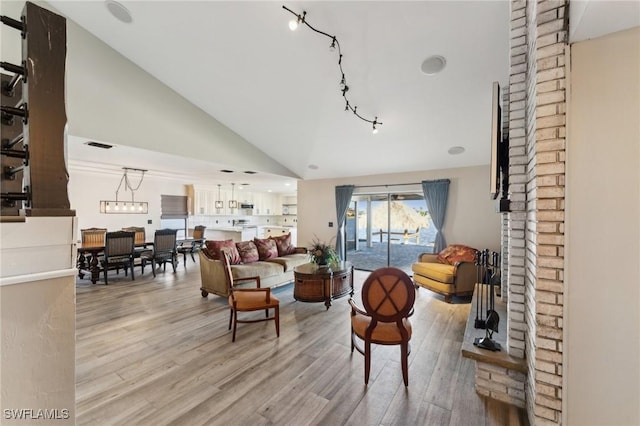 living room featuring light hardwood / wood-style floors and vaulted ceiling