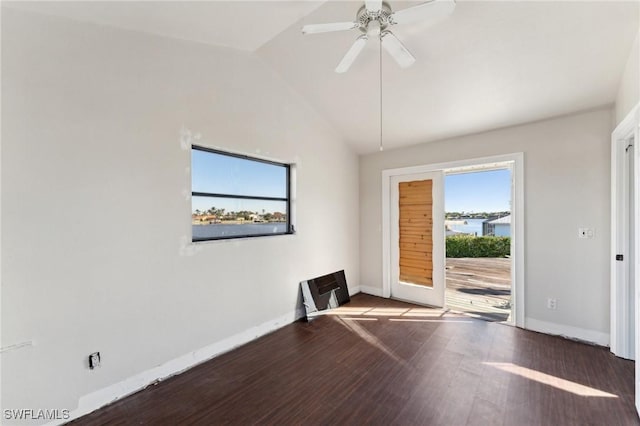 spare room with ceiling fan, vaulted ceiling, and dark wood-type flooring