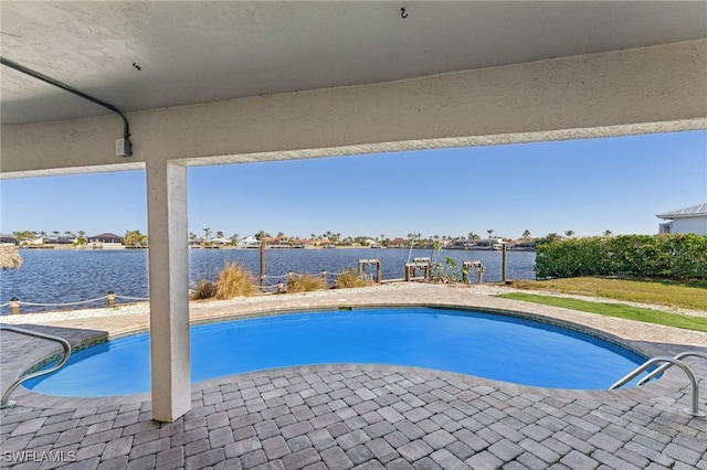 view of pool featuring a patio area and a water view