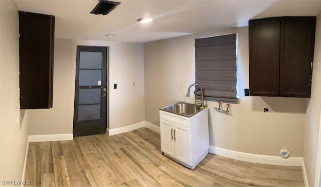 washroom with cabinets, light hardwood / wood-style flooring, and sink