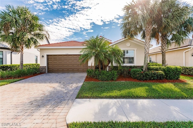 view of front of property with a front lawn, decorative driveway, an attached garage, and stucco siding