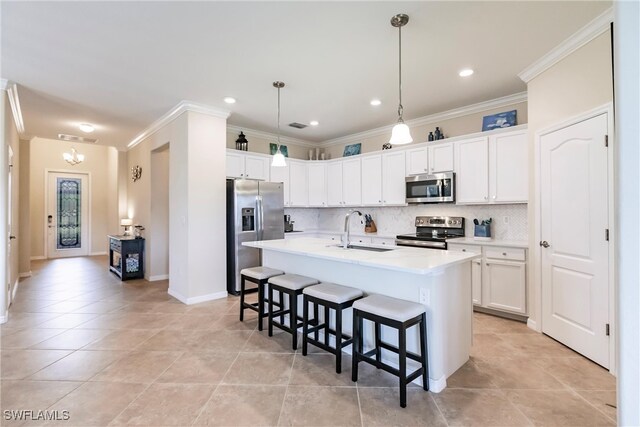 kitchen featuring white cabinetry, sink, stainless steel appliances, a center island with sink, and ornamental molding