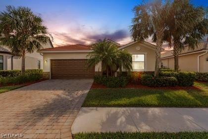 view of front of property featuring a garage, decorative driveway, and stucco siding