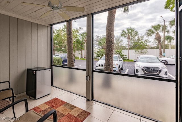 unfurnished sunroom with ceiling fan and wooden ceiling