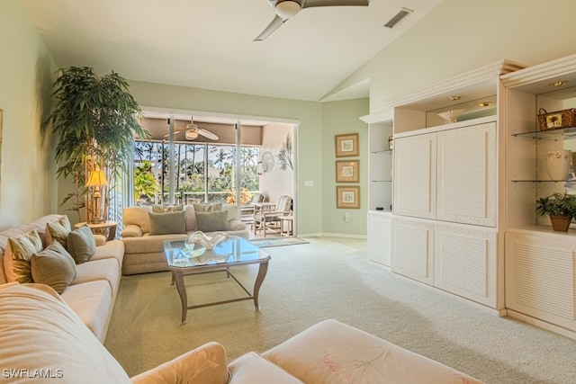 carpeted living room with ceiling fan and vaulted ceiling