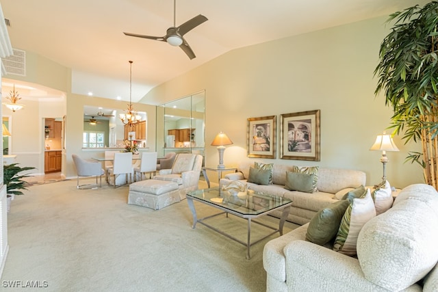 carpeted living room featuring ceiling fan with notable chandelier and vaulted ceiling