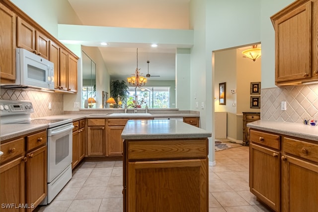 kitchen with a kitchen island, white appliances, sink, and tasteful backsplash