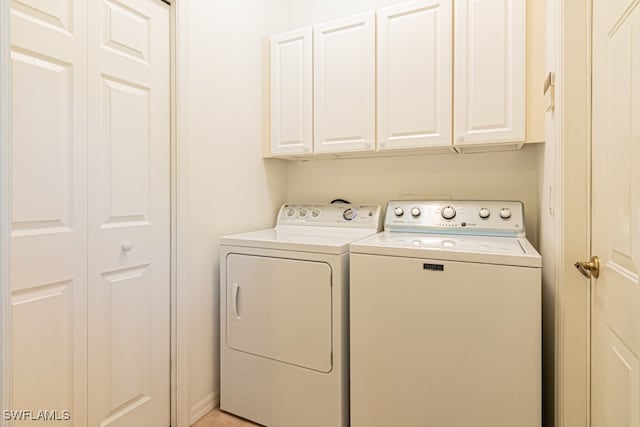 washroom with cabinets and washer and dryer