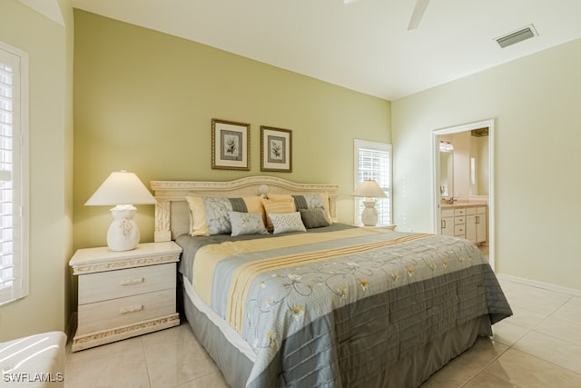 tiled bedroom featuring ensuite bathroom and ceiling fan