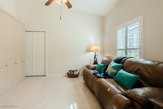 tiled living room featuring ceiling fan and high vaulted ceiling