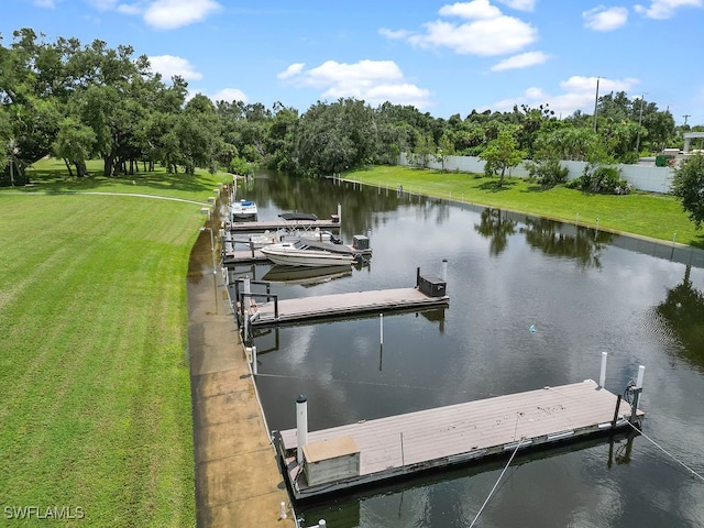 view of dock featuring a lawn and a water view