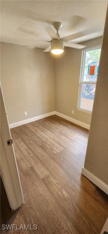 unfurnished room with a textured ceiling, hardwood / wood-style flooring, and ceiling fan