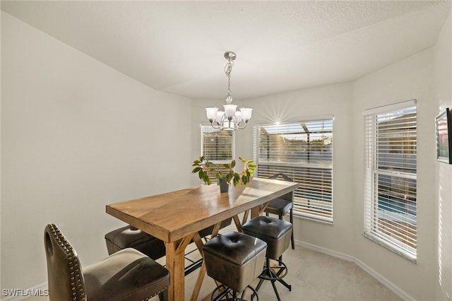 dining space with a chandelier and baseboards