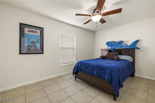 bedroom with ceiling fan, baseboards, and light tile patterned floors