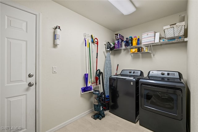 laundry area featuring laundry area, washing machine and dryer, and baseboards