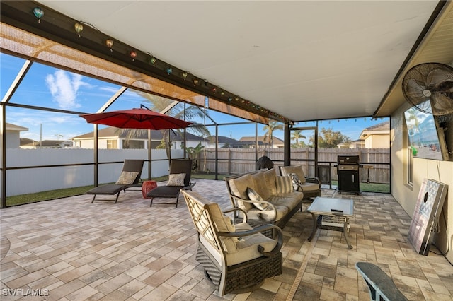 view of patio featuring glass enclosure, grilling area, outdoor lounge area, and a fenced backyard