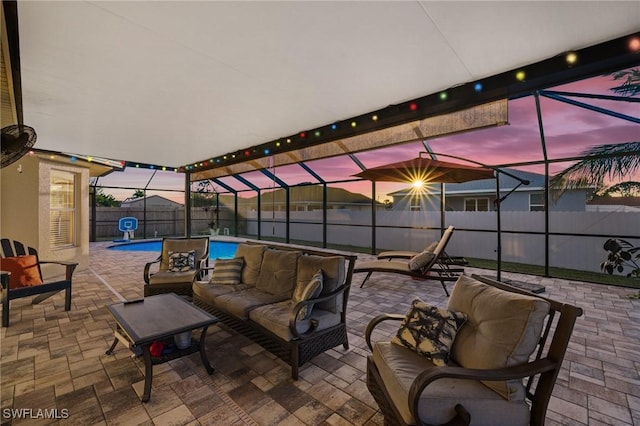 patio terrace at dusk with glass enclosure, outdoor lounge area, a fenced backyard, and a fenced in pool