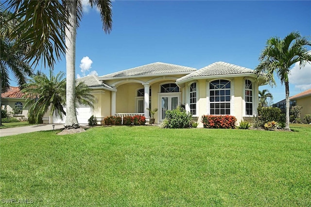 mediterranean / spanish-style home with a front yard and a garage