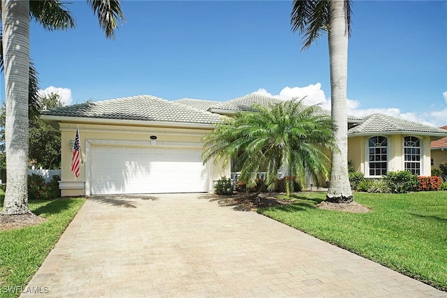 view of front of property featuring a front yard and a garage