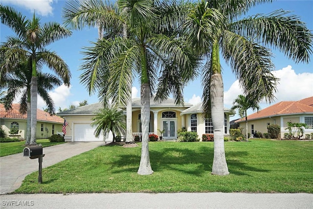 view of front of home with french doors, a front yard, and a garage