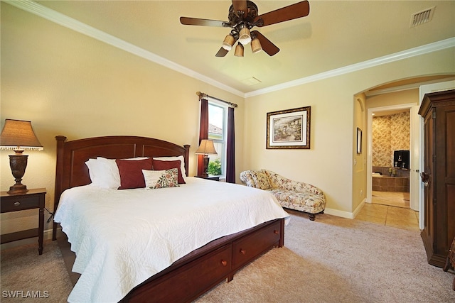 bedroom with ceiling fan, light colored carpet, crown molding, and connected bathroom