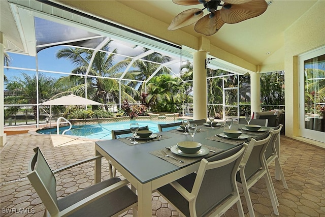 view of swimming pool with a patio, glass enclosure, and ceiling fan