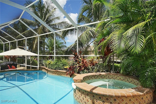 view of pool with glass enclosure and an in ground hot tub