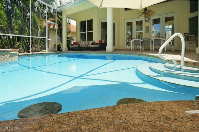 view of pool with french doors, an outdoor living space, ceiling fan, glass enclosure, and a patio area