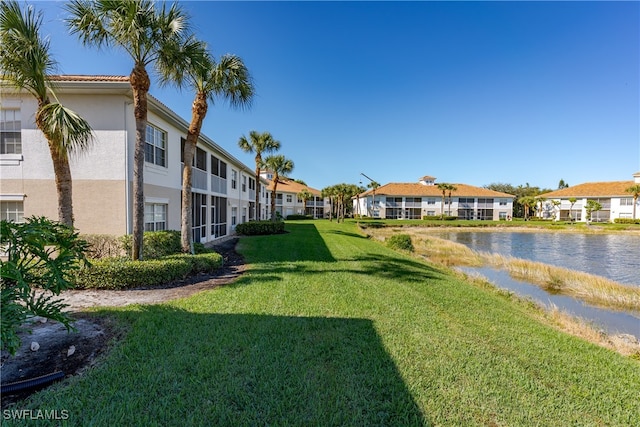 exterior space featuring a lawn and a water view