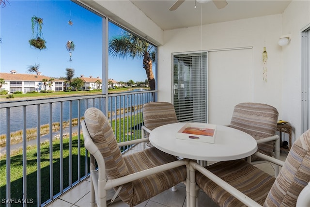 balcony with ceiling fan and a water view