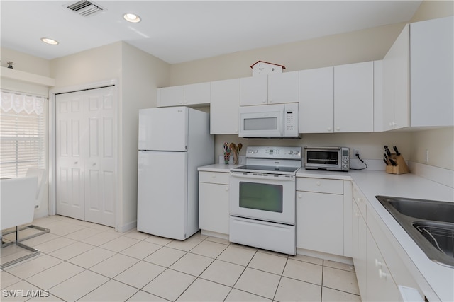 kitchen featuring white cabinets, light tile patterned floors, white appliances, and sink