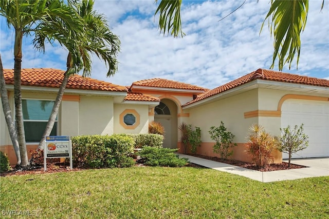 mediterranean / spanish house featuring a garage and a front lawn