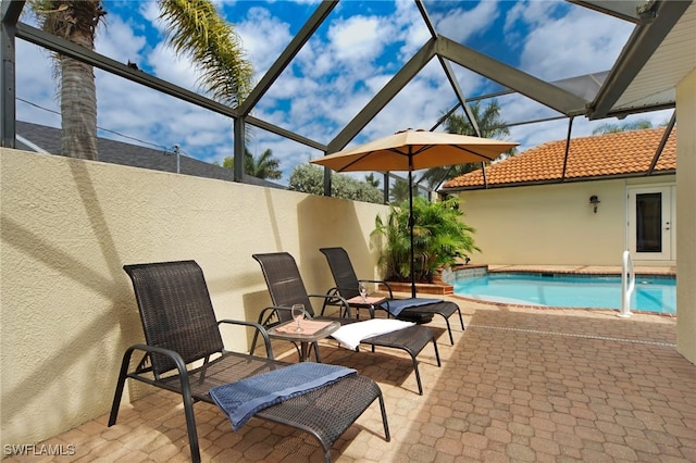 view of pool featuring glass enclosure and a patio area