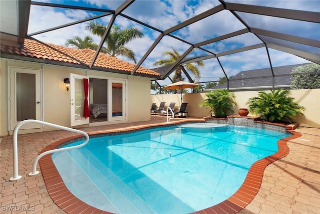 view of pool with pool water feature, a lanai, and a patio