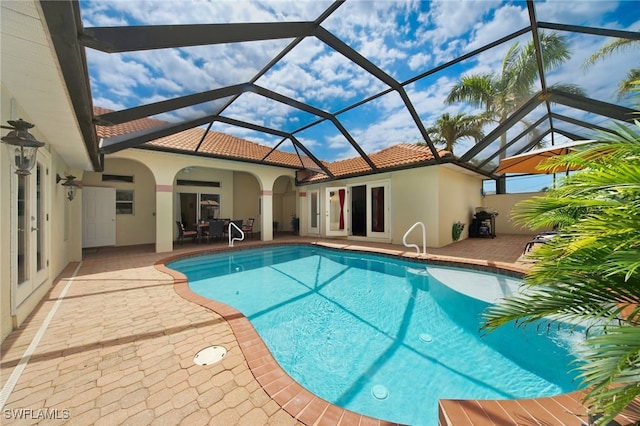 view of pool with a patio area and a lanai