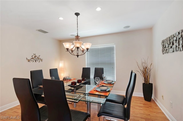 dining area featuring an inviting chandelier and light hardwood / wood-style flooring