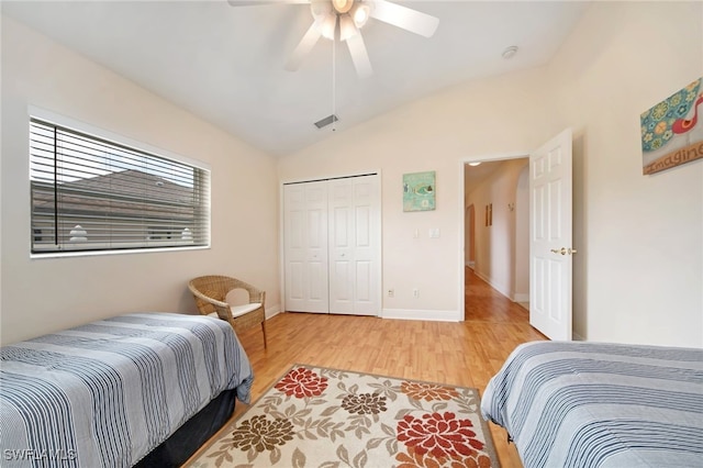 bedroom featuring a closet, hardwood / wood-style flooring, ceiling fan, and lofted ceiling