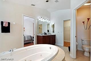 bathroom featuring tile patterned floors, a bathtub, toilet, and vanity