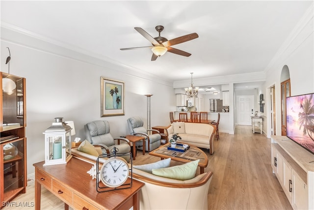 living room with ceiling fan with notable chandelier, crown molding, and light hardwood / wood-style flooring