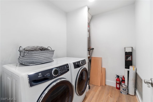 laundry area featuring washer and clothes dryer and light hardwood / wood-style floors