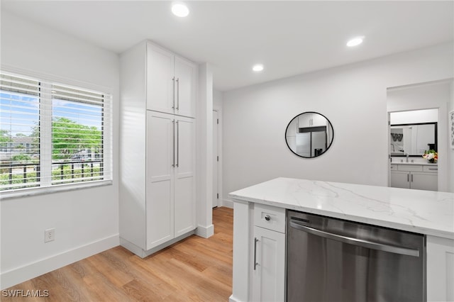 kitchen with white cabinets, light hardwood / wood-style floors, stainless steel dishwasher, and light stone countertops