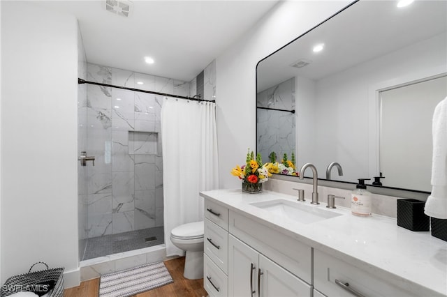 bathroom featuring vanity, hardwood / wood-style flooring, toilet, and curtained shower